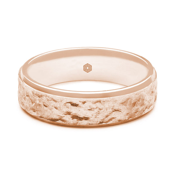 Horizontal Shot of Mens 9ct Rose Gold Flat Court Shape Wedding Ring With a Hammered Finish Bordered by Polished Edges